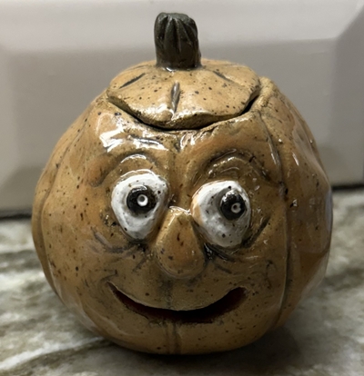 A handmade pumpkin from a pottery class.